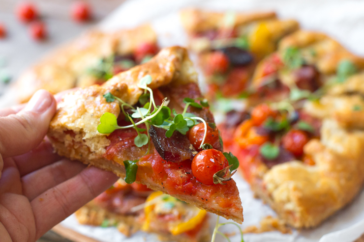 Holding a slice of BeckySues' BLT Galette with Pecorino Pepper Crust