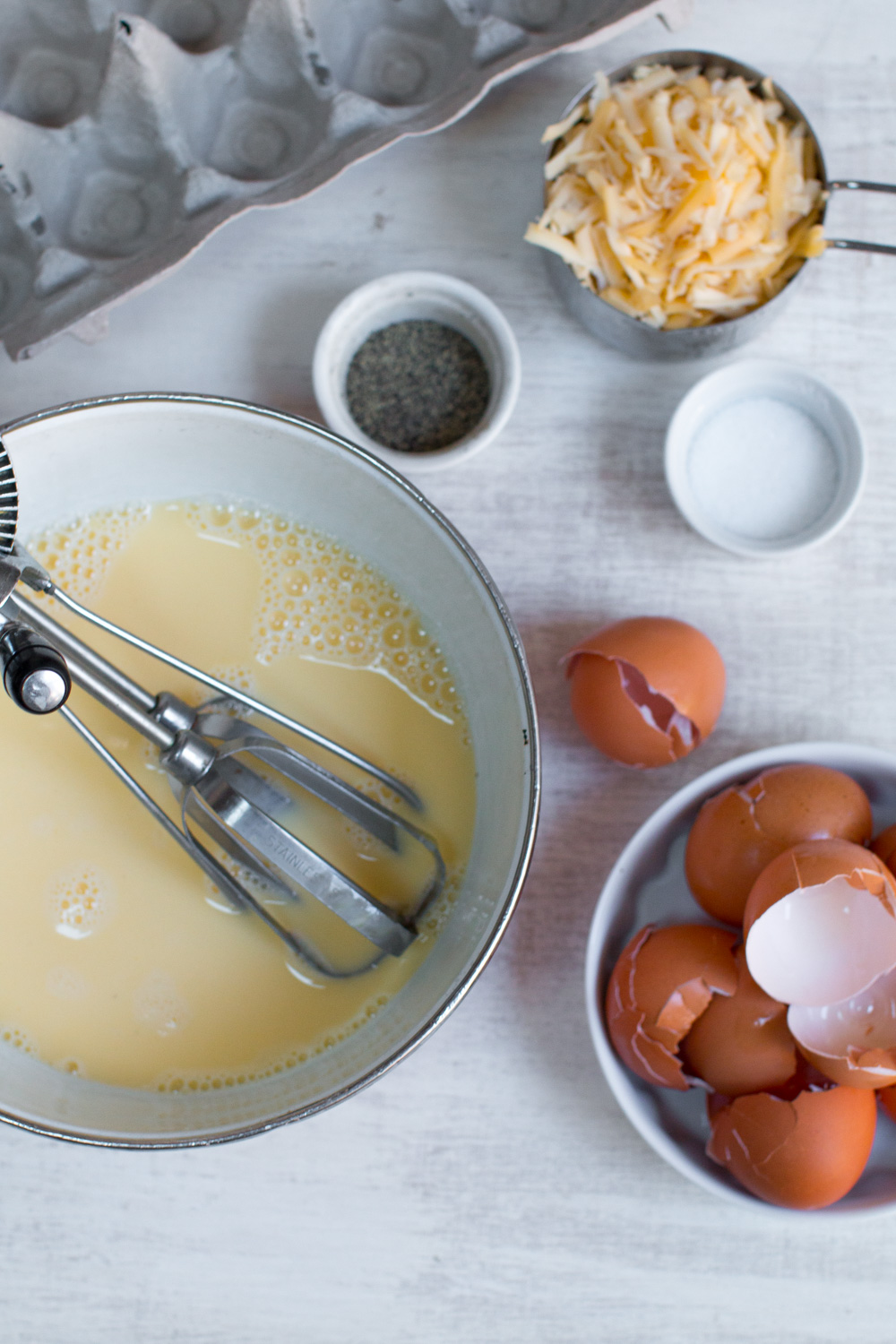 beating eggs Sausage Gouda and Pretzel Strata