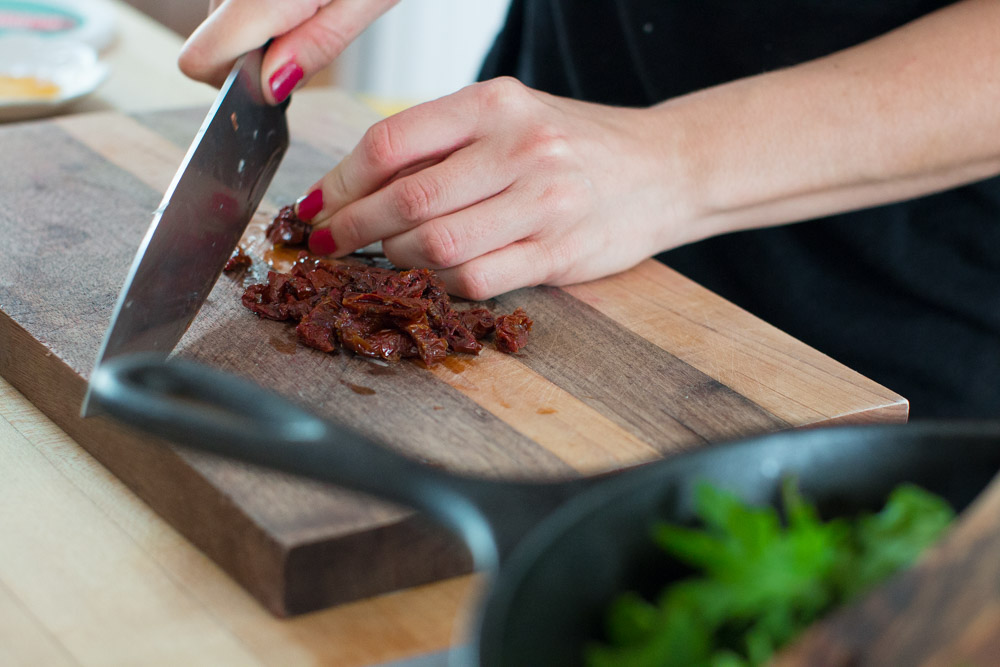 Baked Eggs with Ricotta, Greens & Sun Dried Tomatoes chopping tomatoes chopping sun dried tomatoes