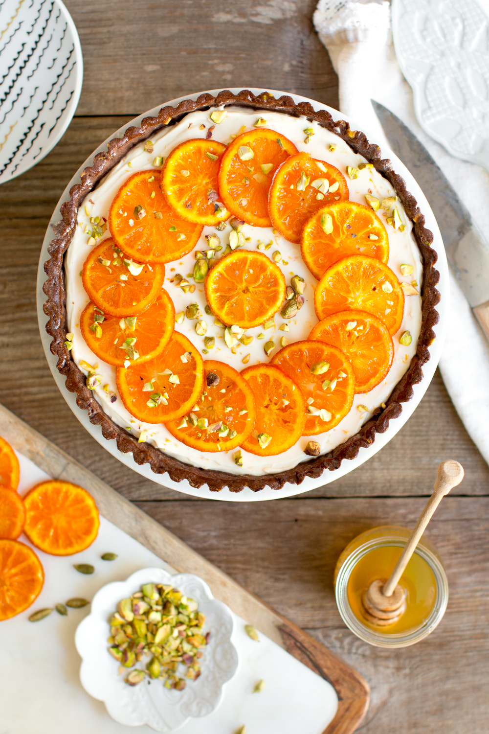 Top the filled chocolate pistachio shell with sunny candied tangerine wheels and chopped pistachios.