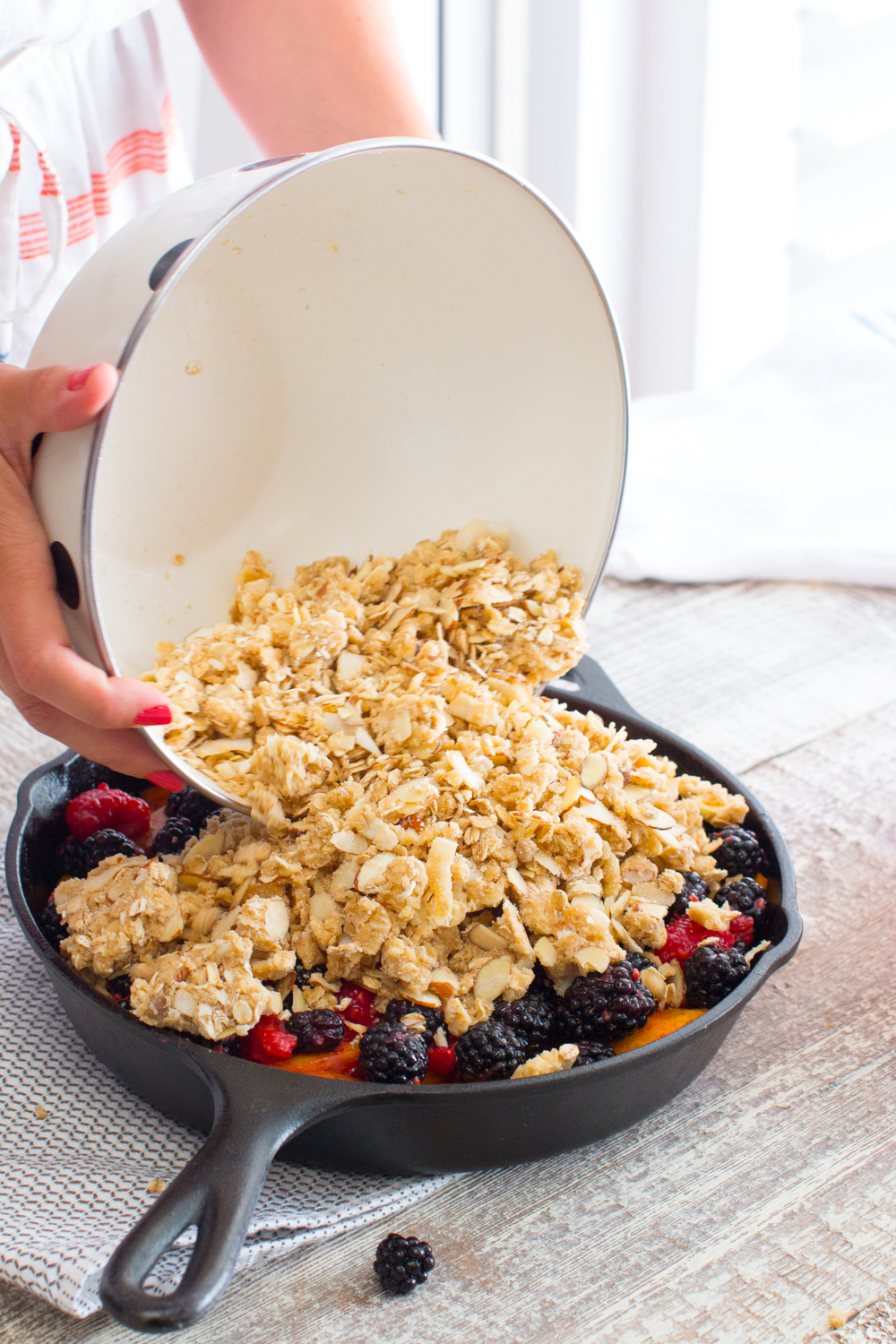 Top the peaches and berries with the chilled crisp topping