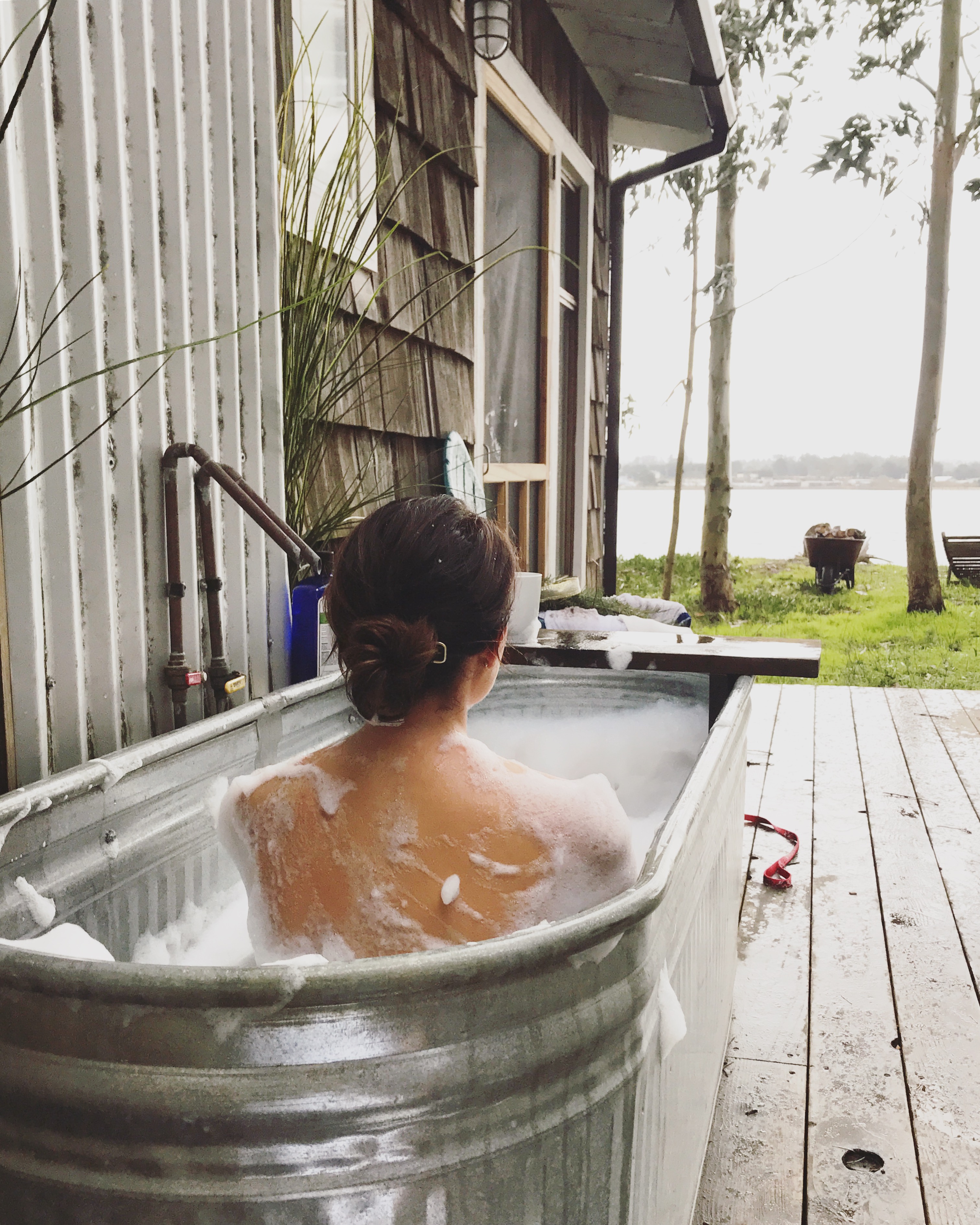 Enjoying an outdoor hail shower in the trough tub at Oyster Beach Social Club