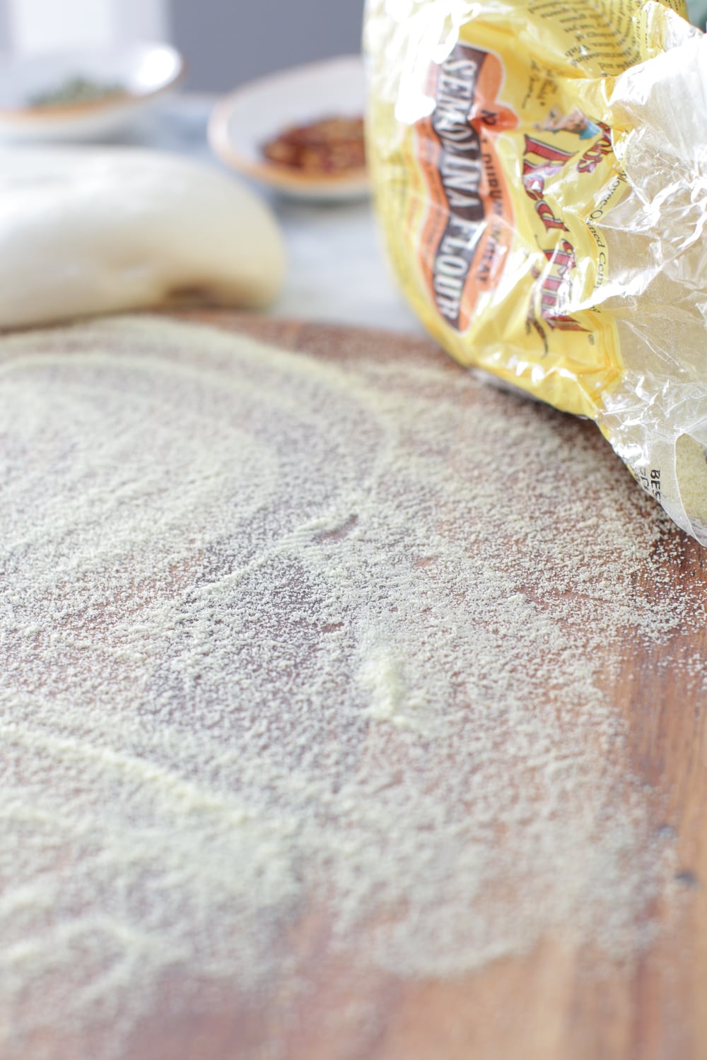 A sprinkle of Semolina Flour from Bob's Red Mill will keep the pizza dough from sticking to the peel by working like a set of ball bearings when transferring the dough to the steel.