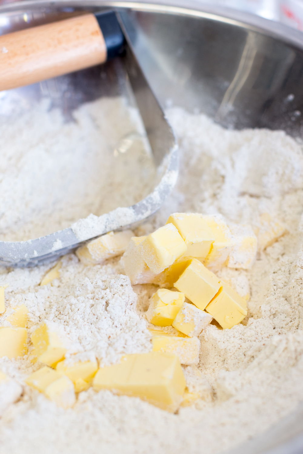 Cutting the ice cold butter into the flour for peach pie dough using a pastry blender.