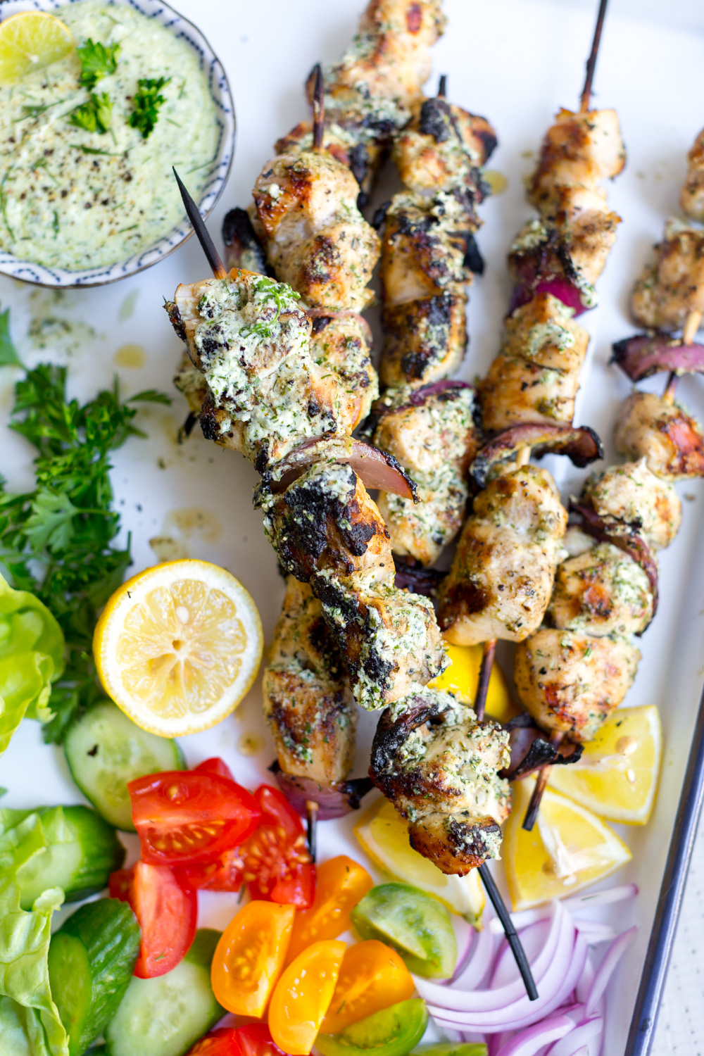 Brush Feta Brined Chicken Skewers with Herby Feta Sauce before serving.