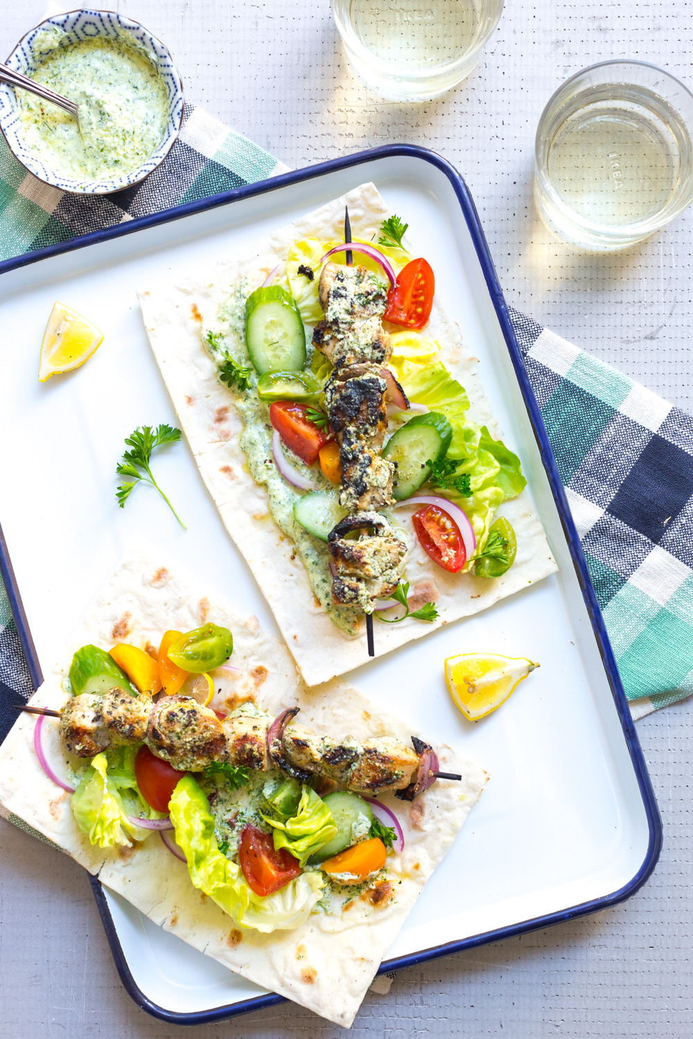 Feta Brined Chicken Skewers with Herby Feta Sauce in a flatbread wrap with white wine.