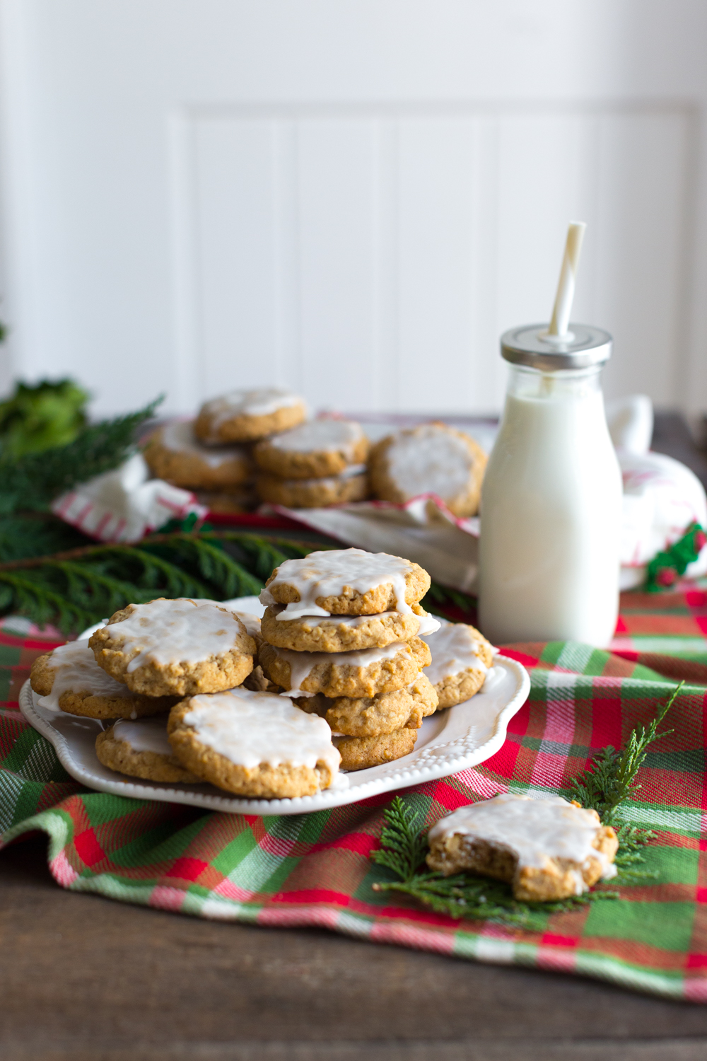 Chinese Five Spice Iced Oatmeal Cookies stacked next to a bottle of milk