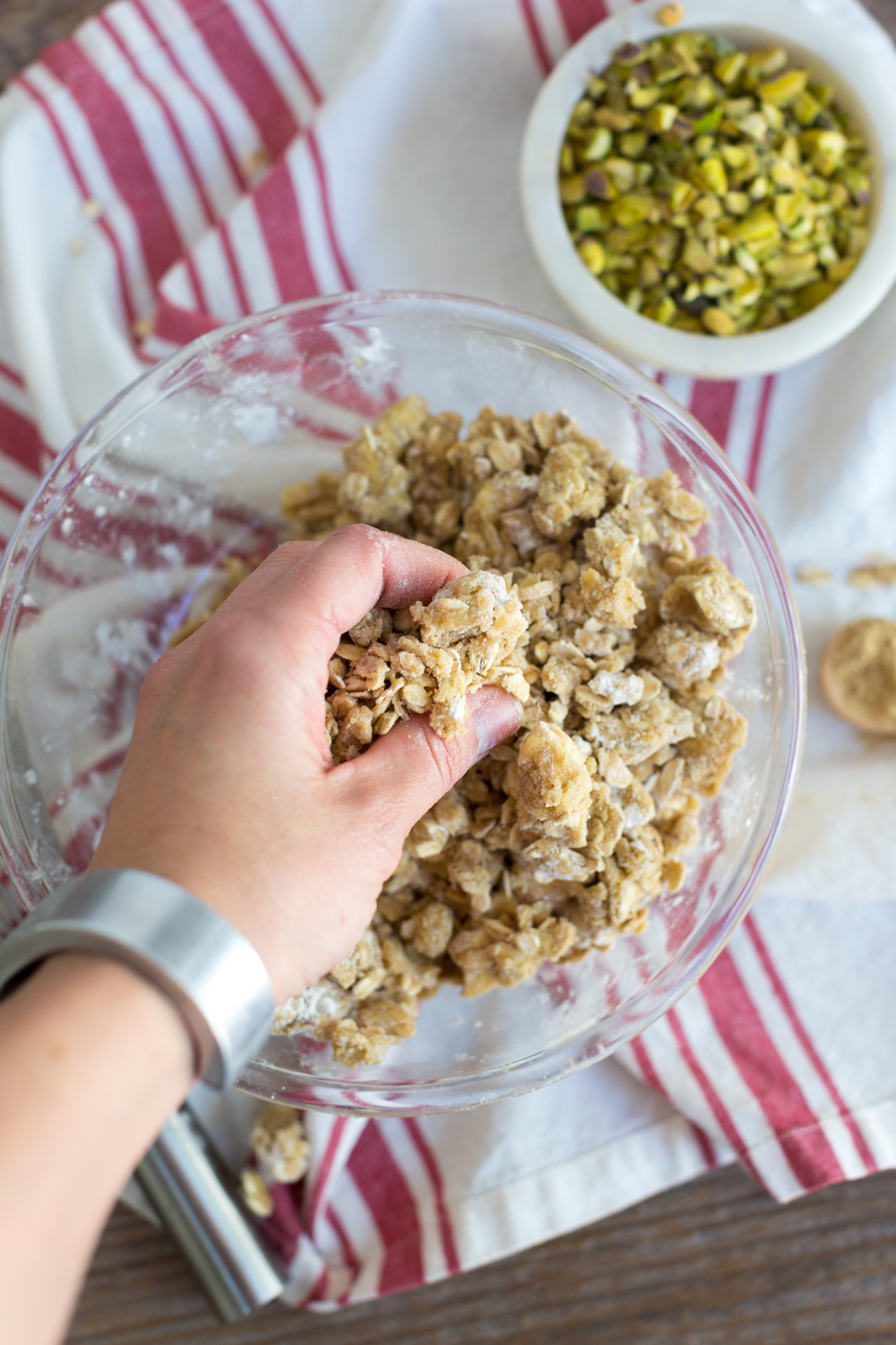 Squishing crisp topping for Strawberry Pistachio Crisp