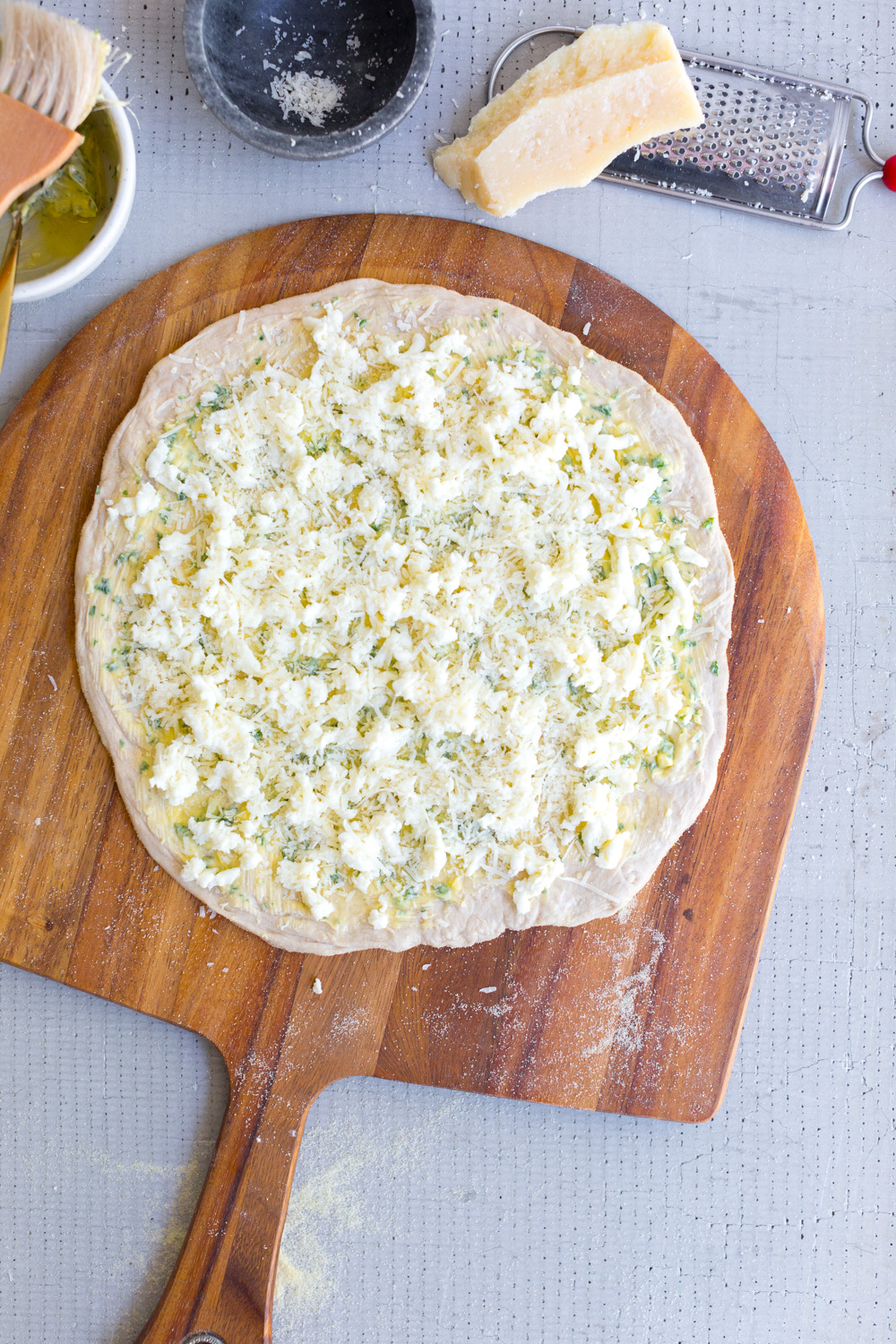 Cheesy Garlic Bread Pizza - topped with cheese.