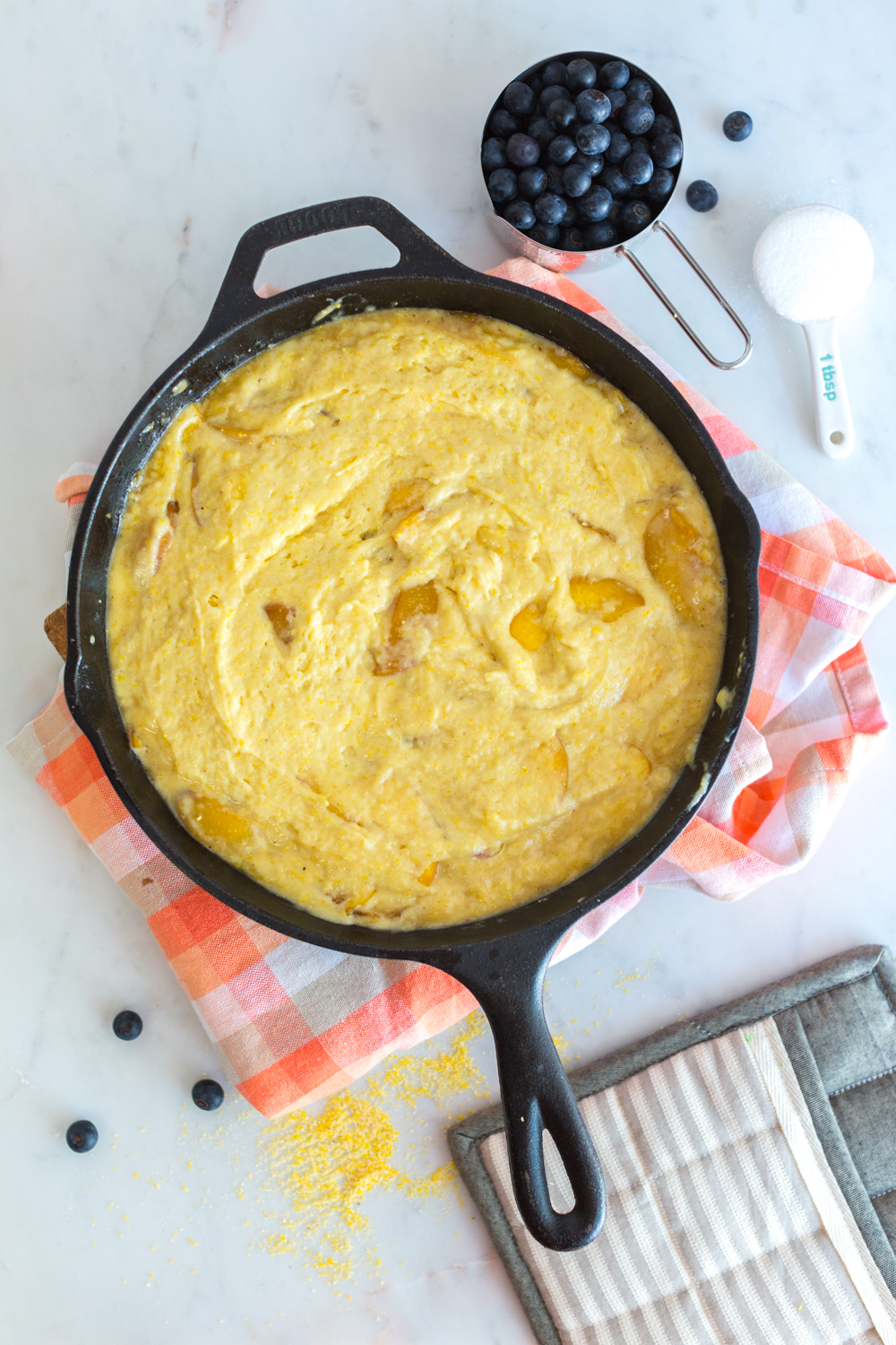 Blueberry Peach Cornmeal Skillet Cake batter in skillet