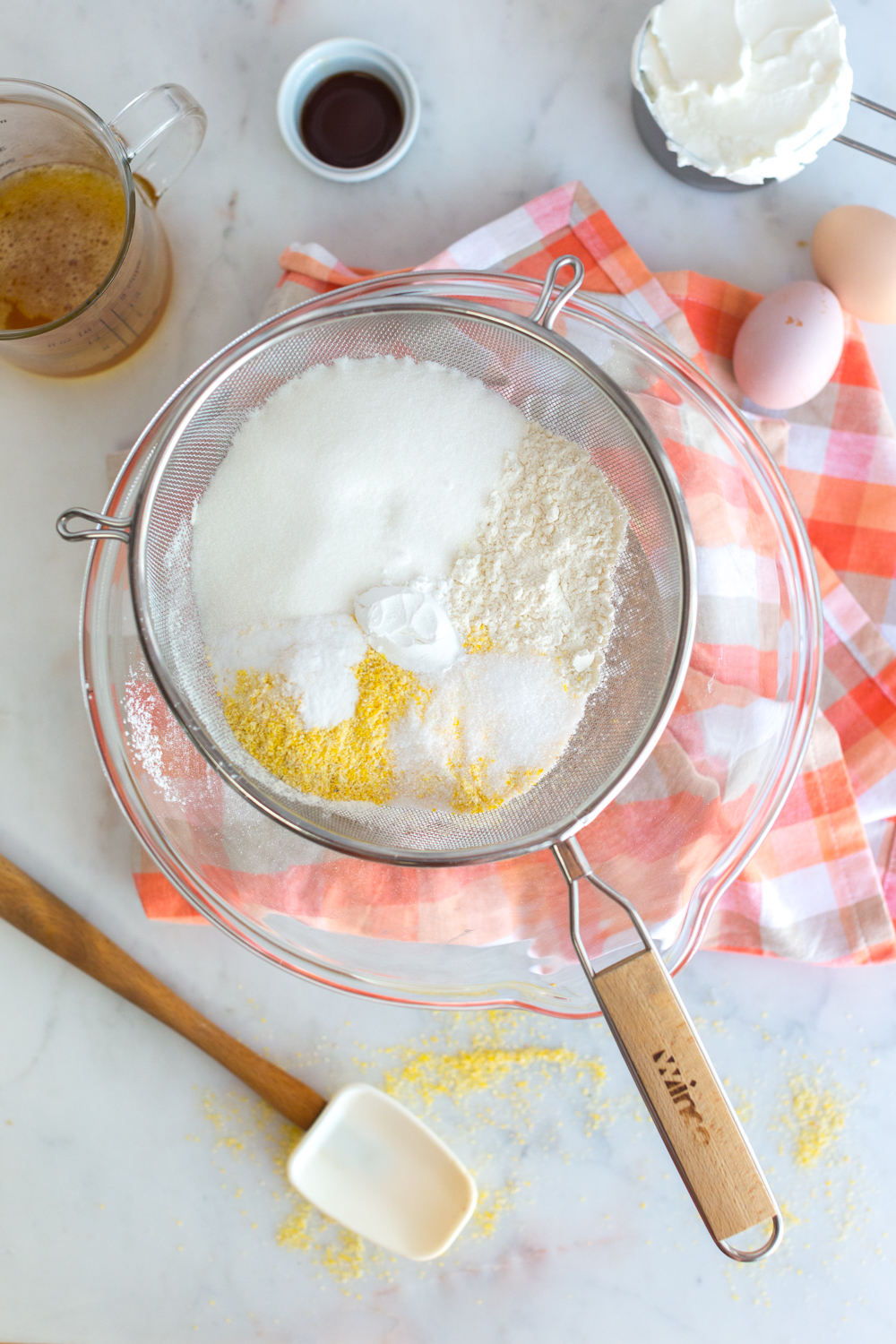 Sifting dry ingredients for Blueberry Peach Cornmeal Skillet Cake