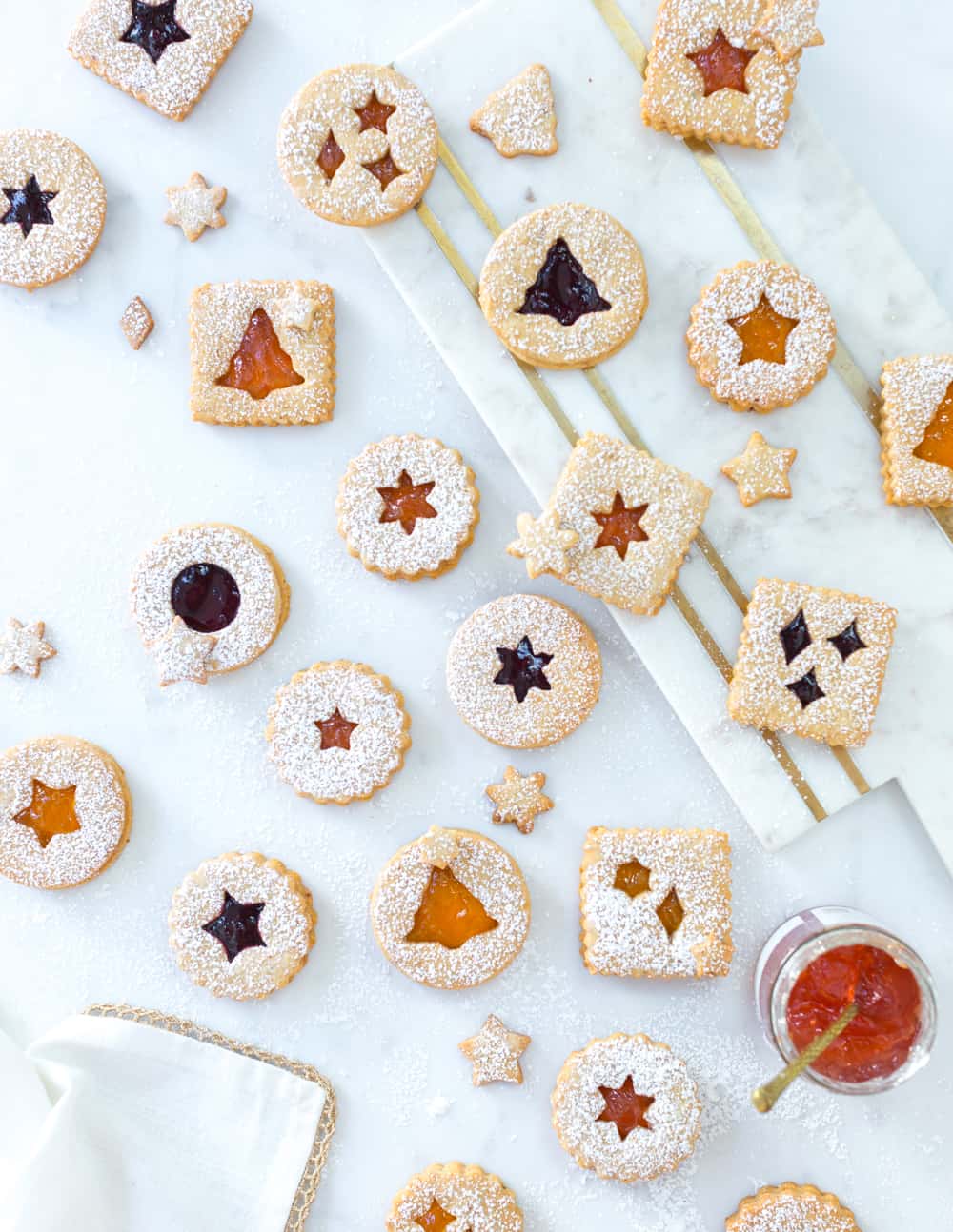 Hazelnut Linzer Cookies with Wine Infused Jam shot from above on multi layered marble surfaces with gold inlay