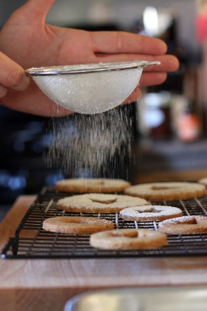 Sifting powdered sugar onto cookies