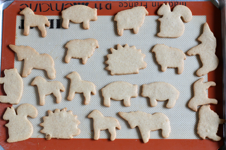 animal cookie shapes on a cookie sheet with toasted edges after baking
