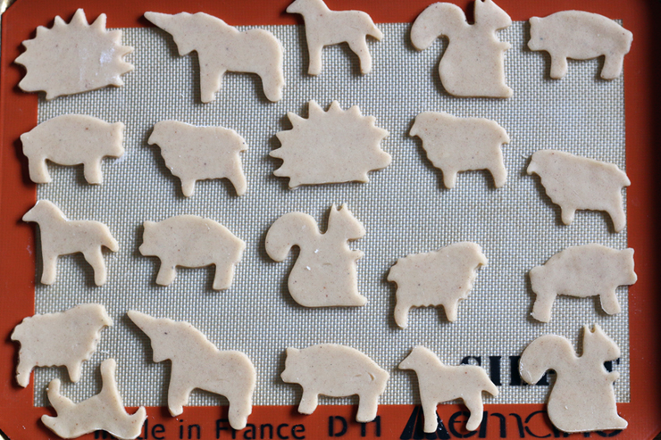 animal cookie dough shapes laid out on a cookie sheet before baking