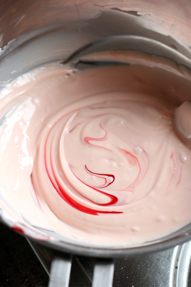 red food coloring swirling into the frosting to make it animal cookie pink