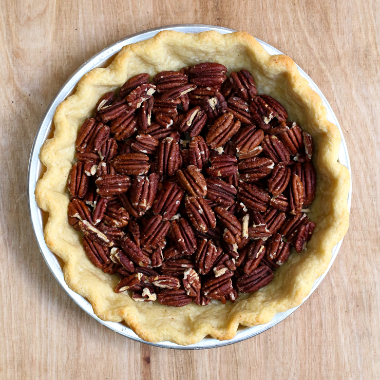 Line the pre baked pie shell with the toasted pecans.