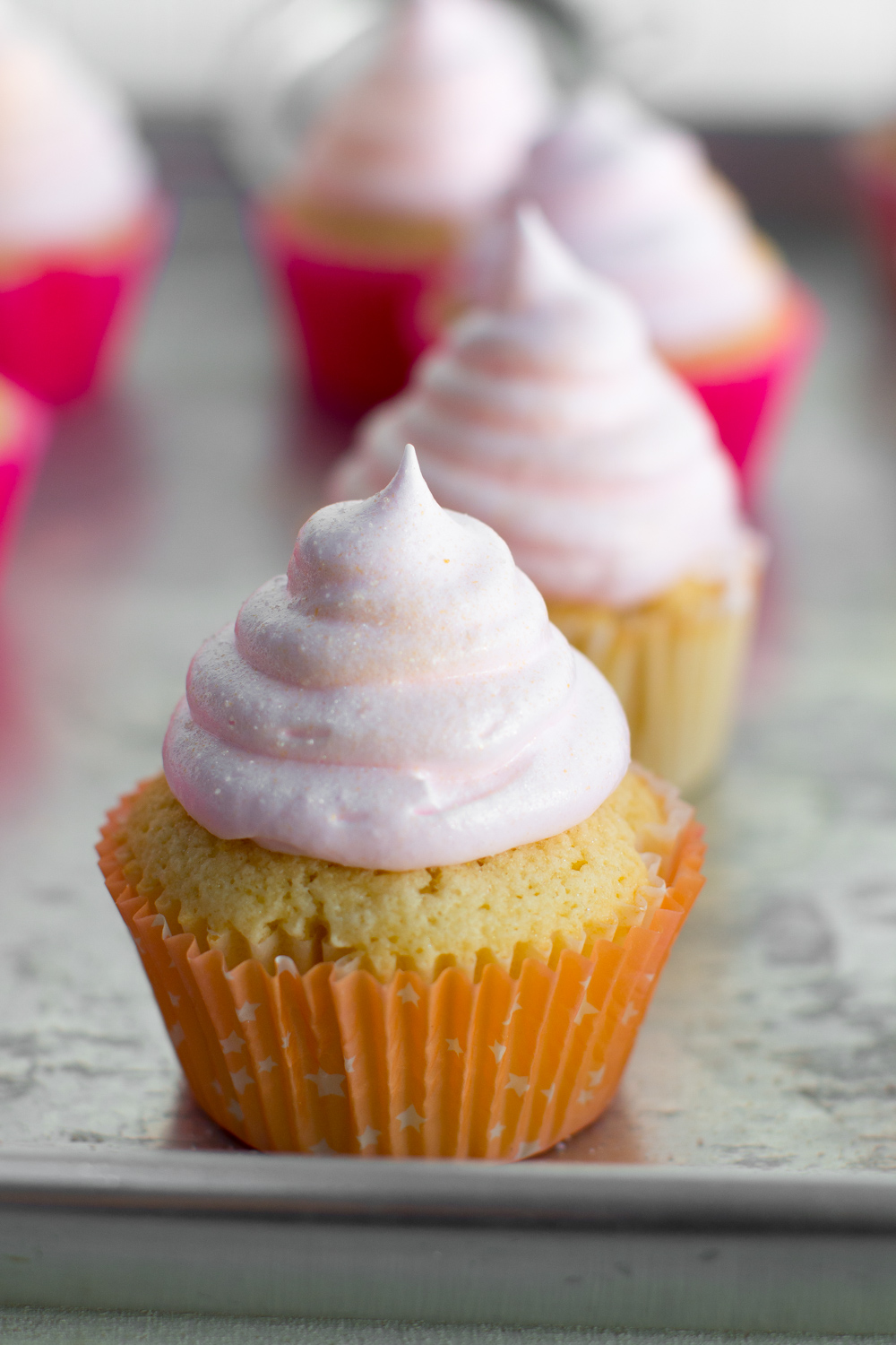 a super close up shot of a finished pink champagne meringue cupcake