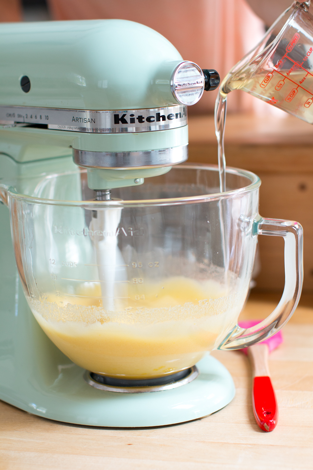 pouring coconut oil into the cupcake batter