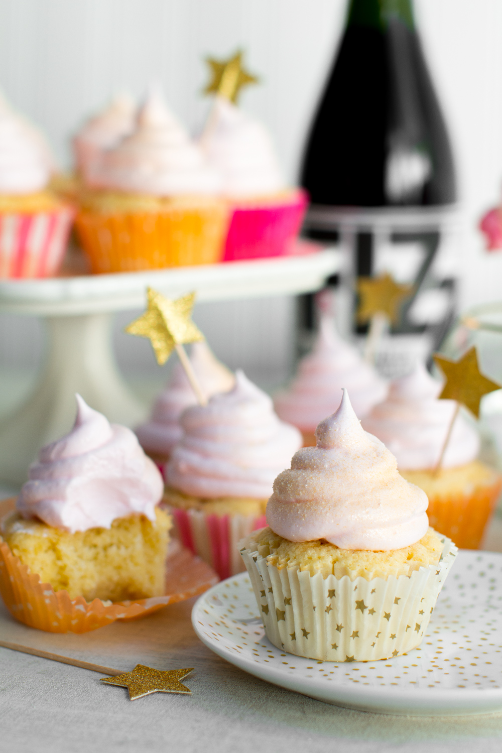 Champagne Meringue Cupcakes next to a bottle of champagne