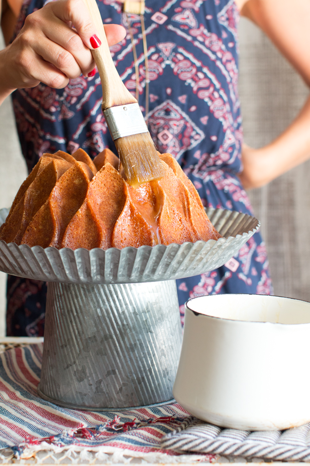 glazing brown butter bourbon bundt cake with a brush