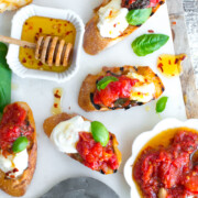 Tomato Confit & Burrata Crostini with a spicy sweet drizzle of chili honey