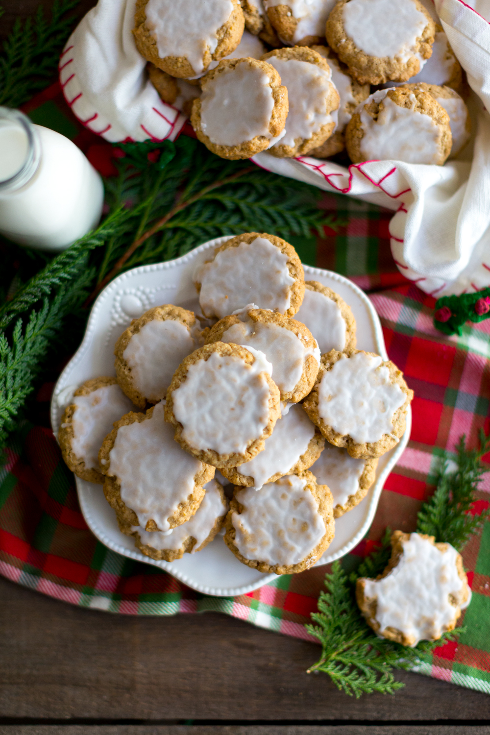 Plate of Chinese Five Spice Iced Oatmeal Cookies next to a bottle of milk with holiday decor - overhead angle
