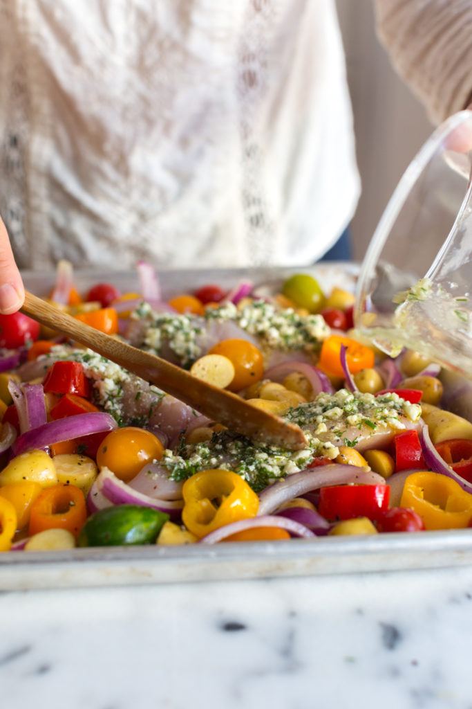 adding herby feta marinade over the chicken breasts