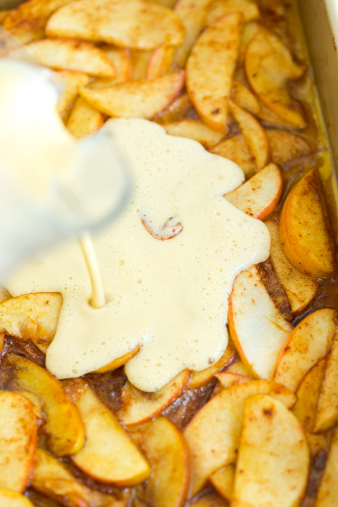 Pouring the pancake batter over the apples