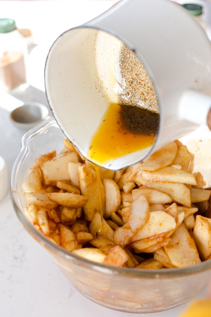 pouring vanilla browned butter over pie filling