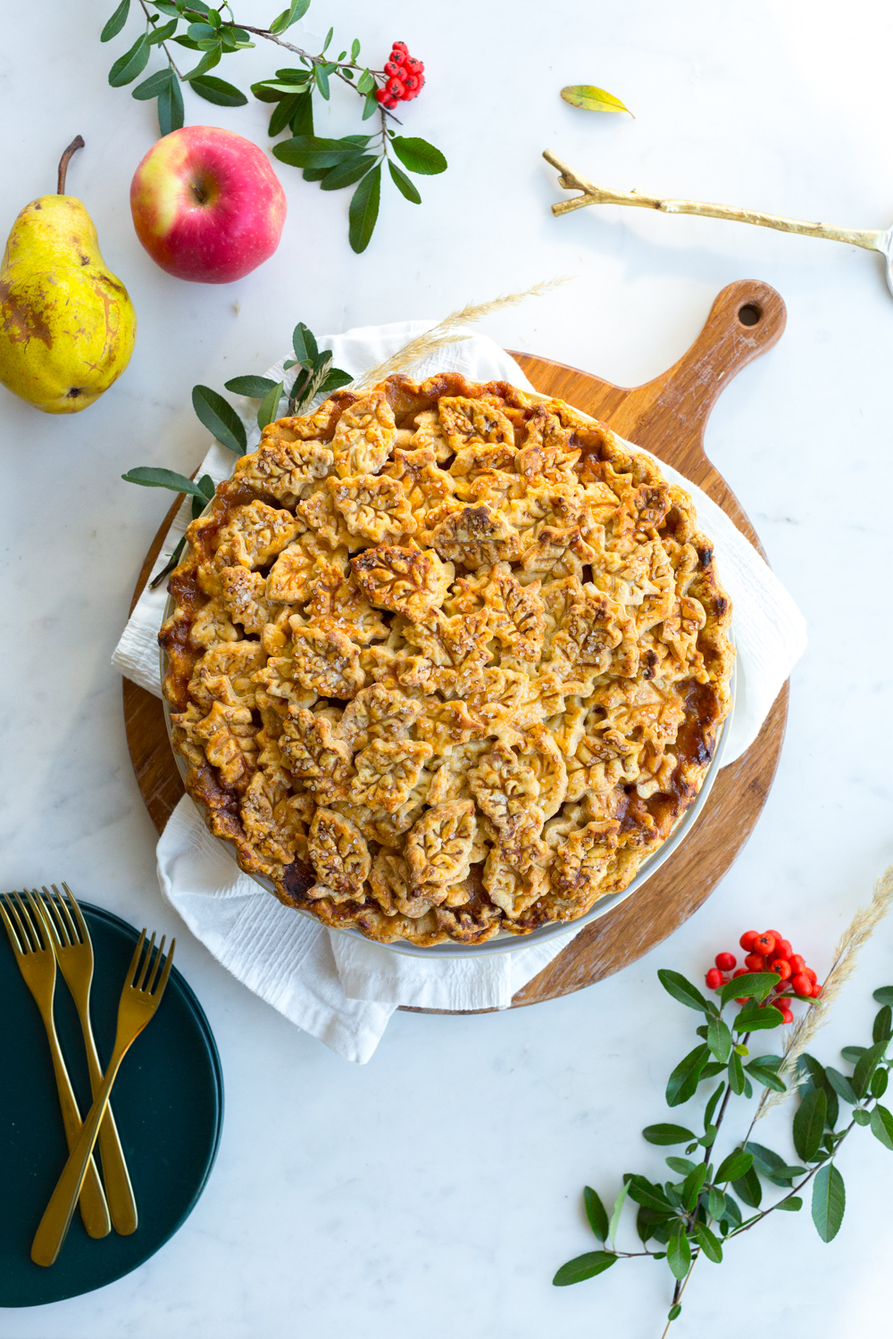 Apple Pear Gruyere Pie with leafy crust baked and cooling on a hot plate