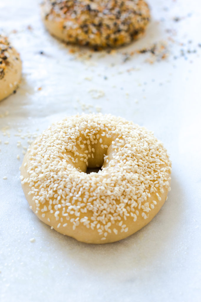 a sesame seed topped bagel before baking