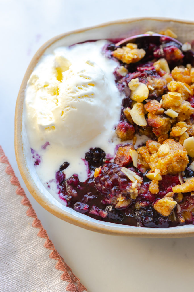 Mixed Berry Oat Almond Crisp with a scoop of vanilla ice cream