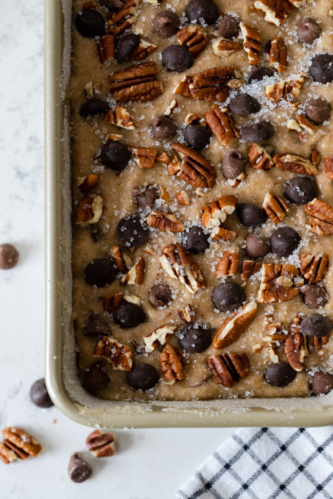 Topping Brown Butter Pecan Chocolate Chip Banana Bread batter in pan