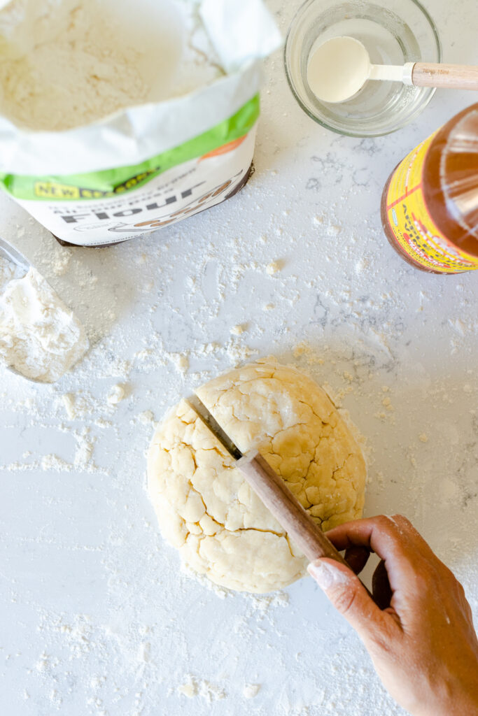 slicing the Basic All Butter Pie Dough into two halves
