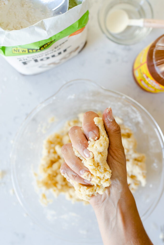 checking pie dough hydration with a gentle squeeze