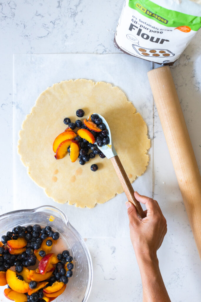 Topping Galette dough with blueberry peach filling