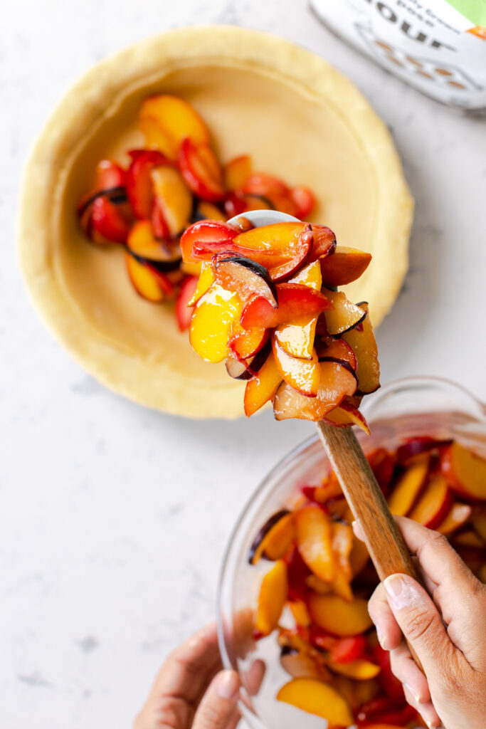 adding stone fruit to bottom pie dough