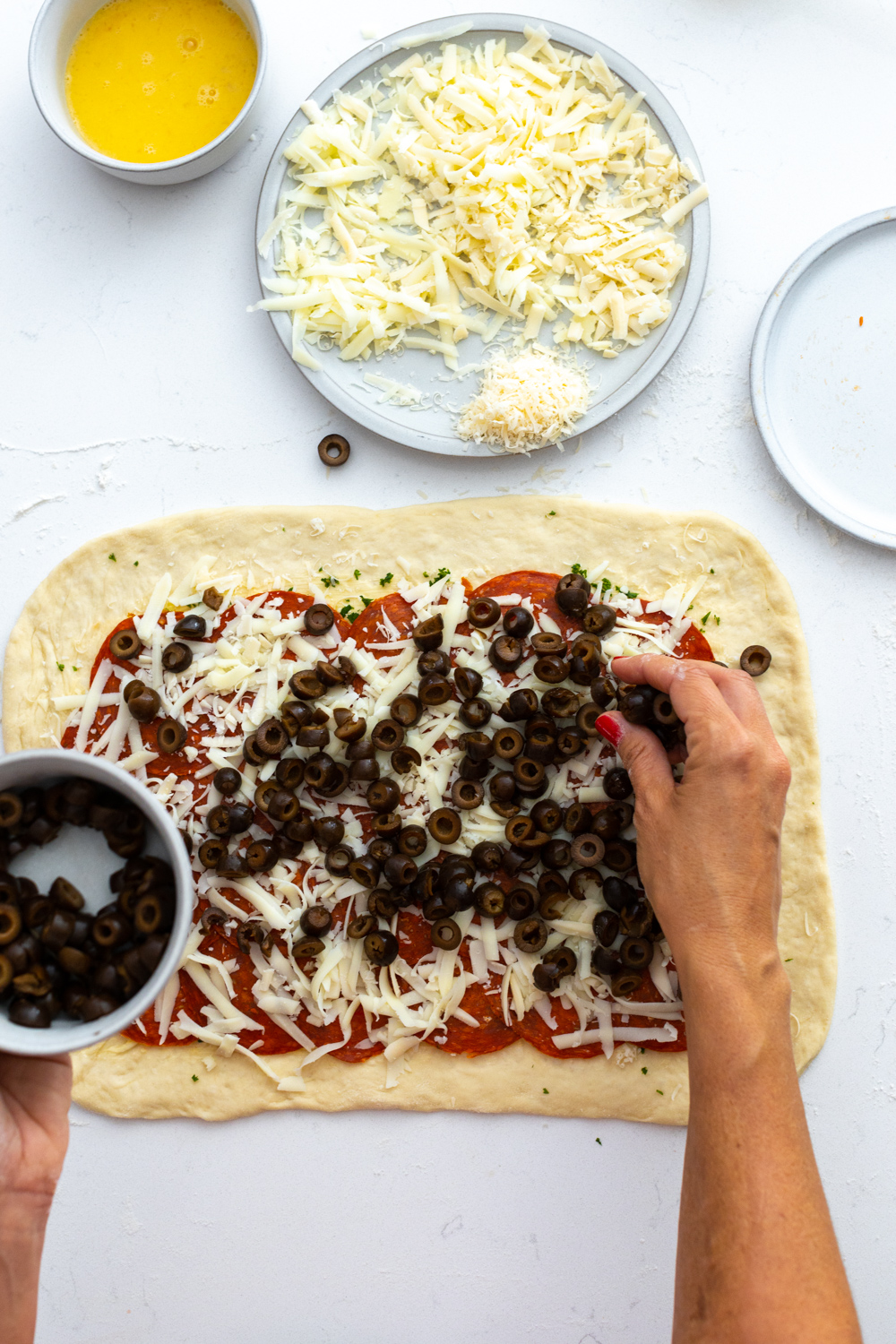 layering black olives on Stromboli