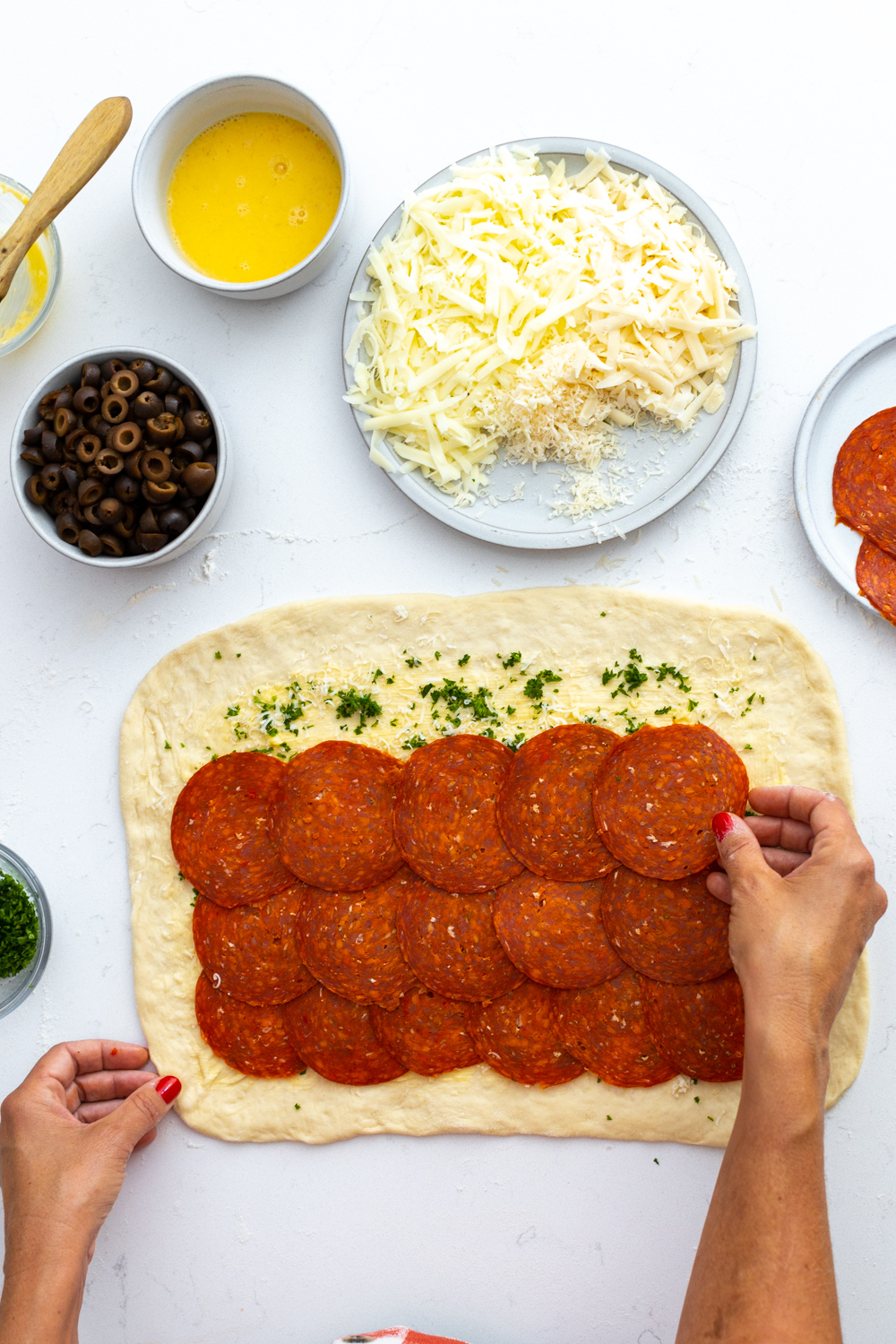 Adding pepperoni to Pepperoni Black Olive Stromboli