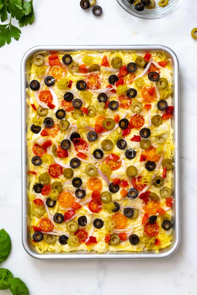 Loaded focaccia pre-baked in a sheet pan