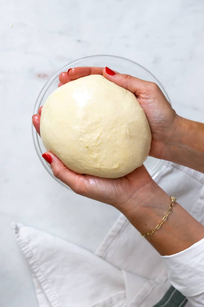 Focaccia bread dough in oily hands