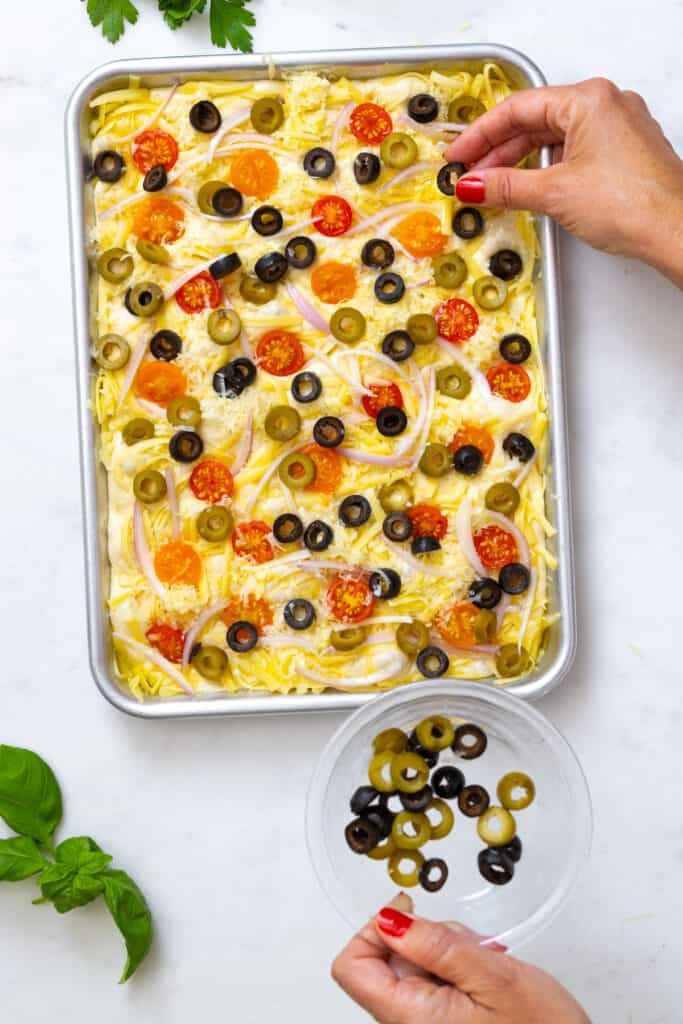 Topping focaccia with olives