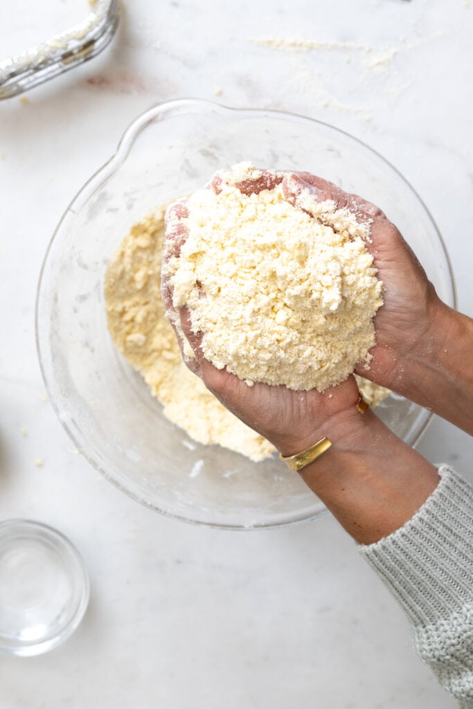 butter cut into pie dough held in two hands to show texture