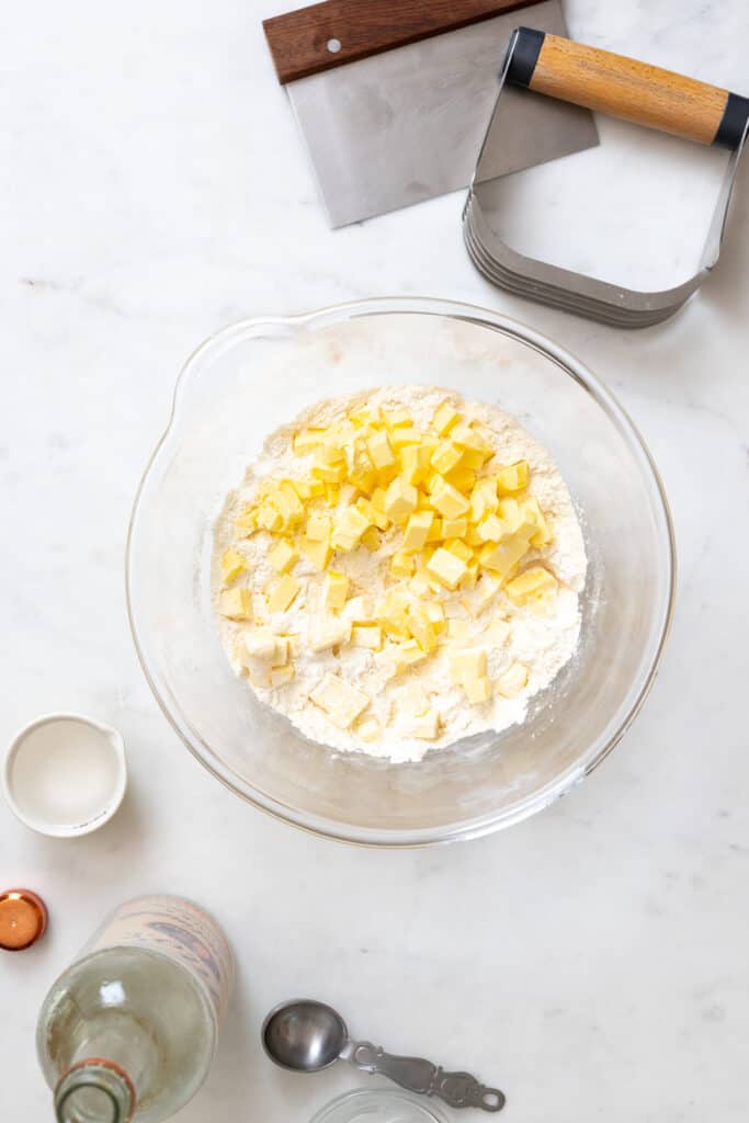 Butter cubes in dry pie dough ingredients in a large mixing bowl