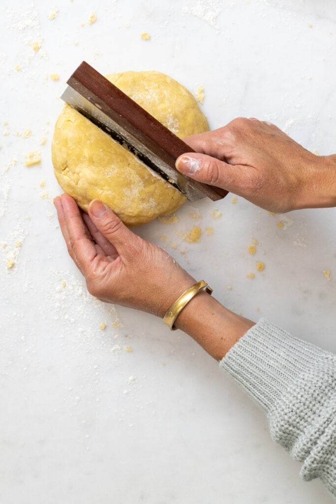 Divide the pie dough in half with a bench knife