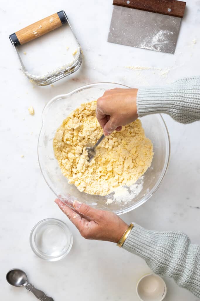 using the back of a fork to smash bring the dough together