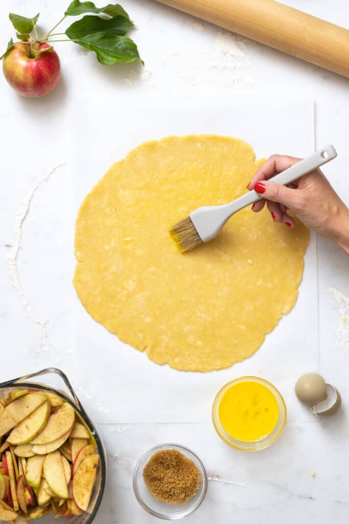 Brushing cheddar pie dough with egg wash