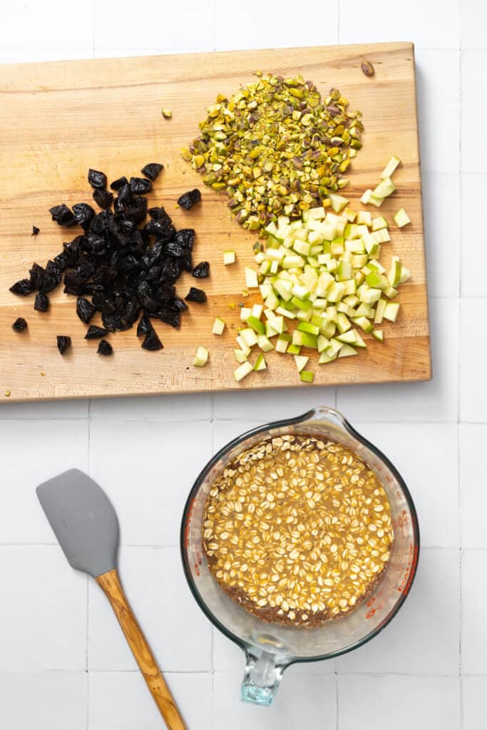 mixing oatmeal with fruit and pistachios