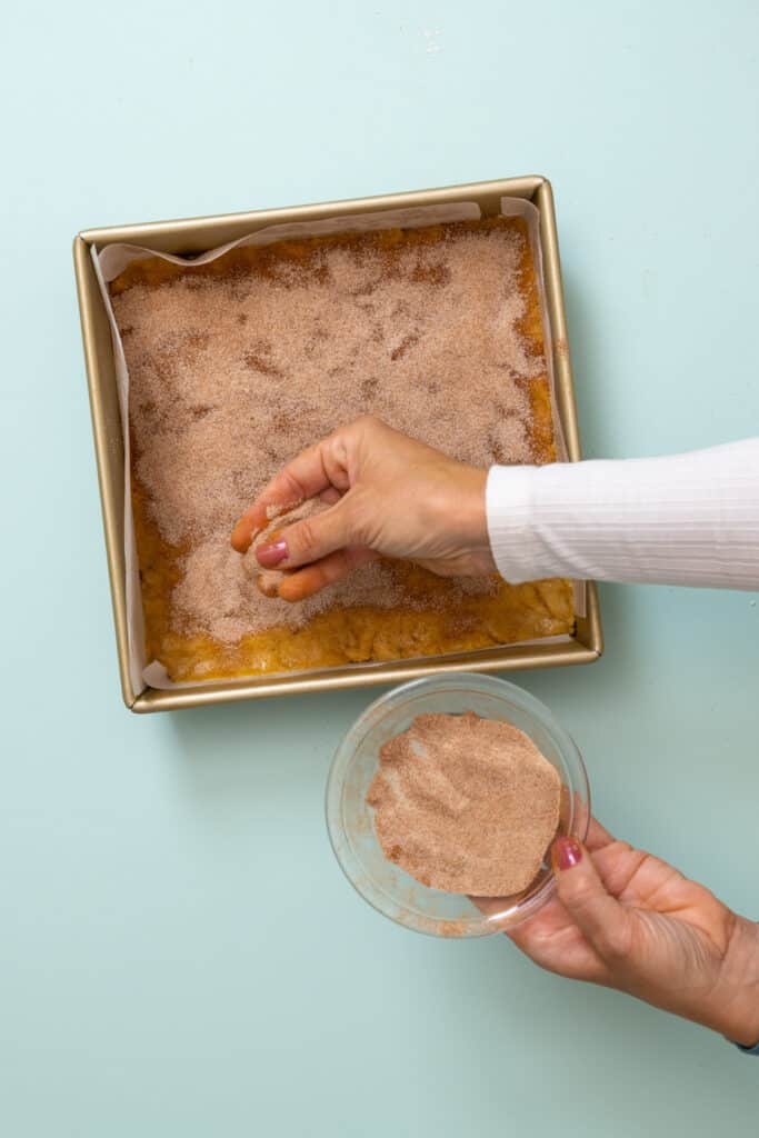 sprinkling cinnamon sugar on blondie batter